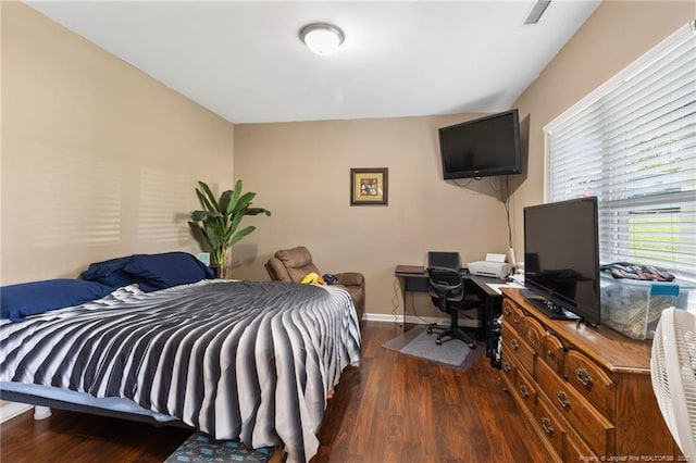 bedroom with baseboards, visible vents, and wood finished floors