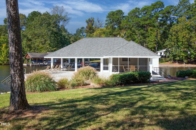 rear view of house featuring a water view and a yard