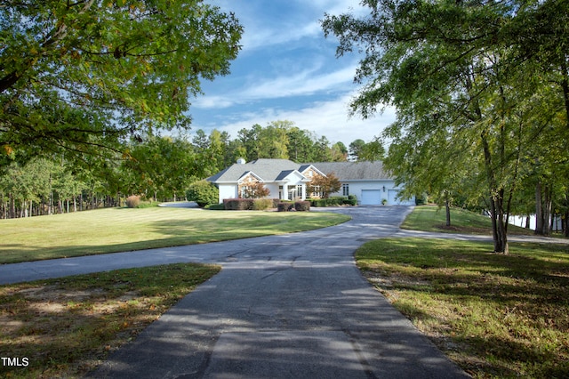 ranch-style house featuring a garage and a front lawn