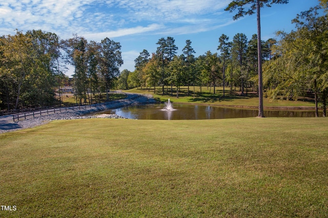 surrounding community featuring a water view and a lawn