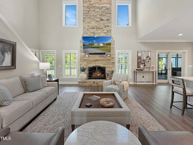 living room featuring a high ceiling, hardwood / wood-style flooring, and a healthy amount of sunlight