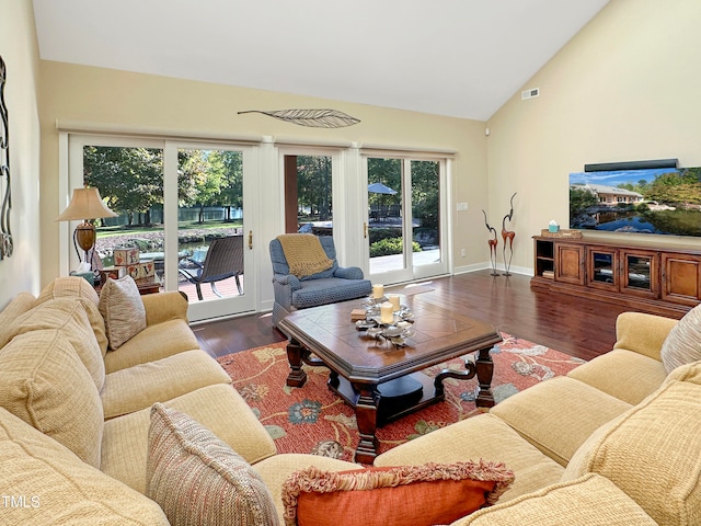 living room with dark wood-type flooring and high vaulted ceiling