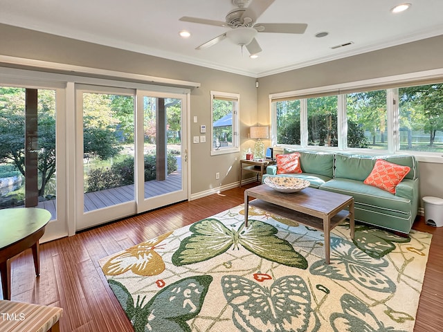 living room with wood-type flooring, ceiling fan, and crown molding