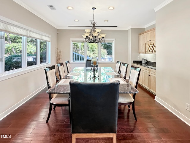 dining space featuring dark hardwood / wood-style floors, a chandelier, and crown molding