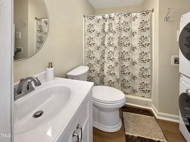 bathroom with stacked washer / dryer, a shower with curtain, vanity, hardwood / wood-style floors, and toilet