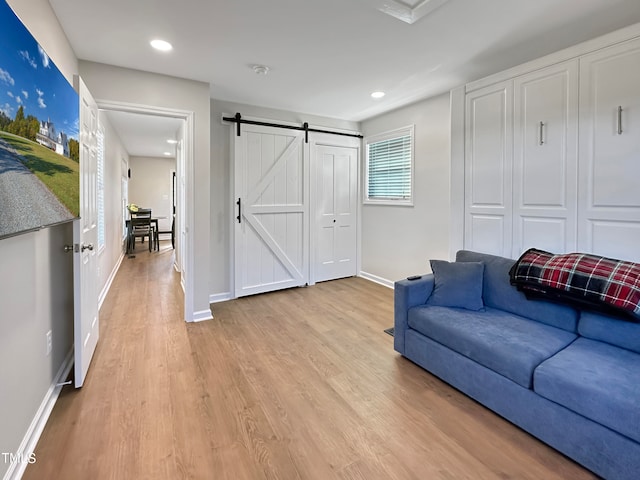 living room featuring a barn door and light wood-type flooring