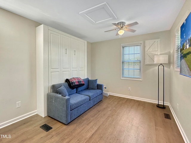 living area featuring hardwood / wood-style floors and ceiling fan