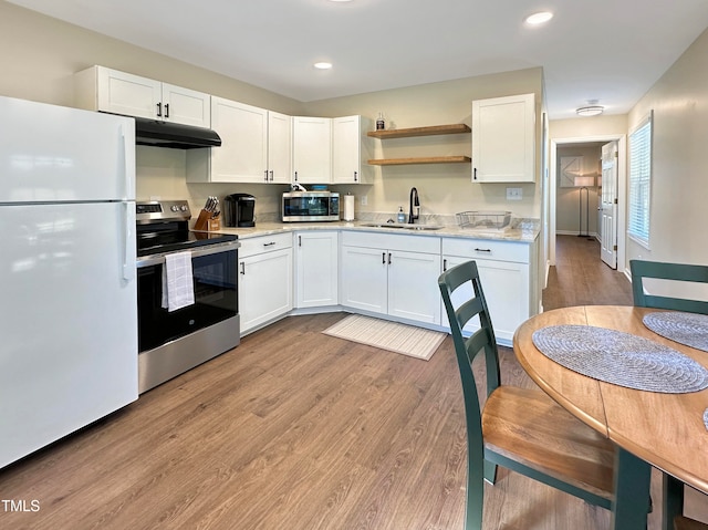 kitchen with white cabinetry, light wood-type flooring, appliances with stainless steel finishes, and sink