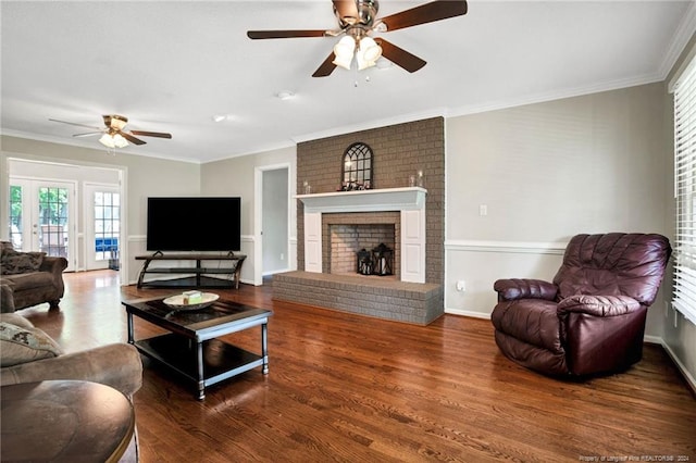 living room featuring ceiling fan, a fireplace, hardwood / wood-style flooring, and crown molding