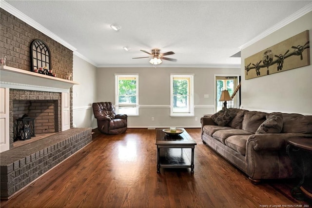 living room with crown molding, dark hardwood / wood-style floors, a brick fireplace, and ceiling fan