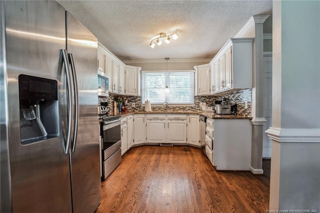 kitchen with white cabinetry, wood-type flooring, tasteful backsplash, and appliances with stainless steel finishes