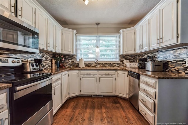 kitchen with appliances with stainless steel finishes, white cabinetry, decorative backsplash, and dark hardwood / wood-style floors