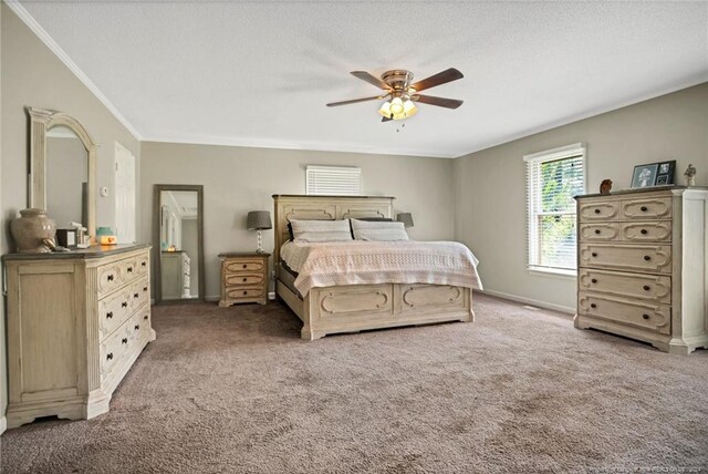 carpeted bedroom featuring ornamental molding and ceiling fan