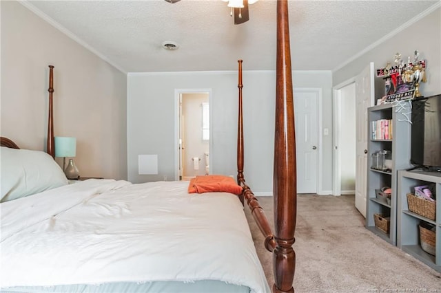 carpeted bedroom featuring ensuite bath, crown molding, and a textured ceiling