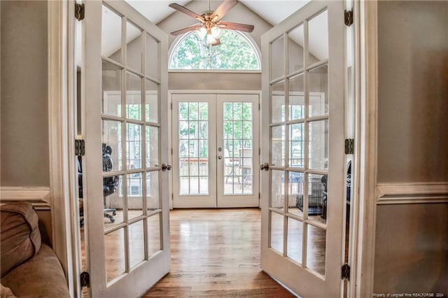 doorway featuring light hardwood / wood-style floors, french doors, high vaulted ceiling, and ceiling fan