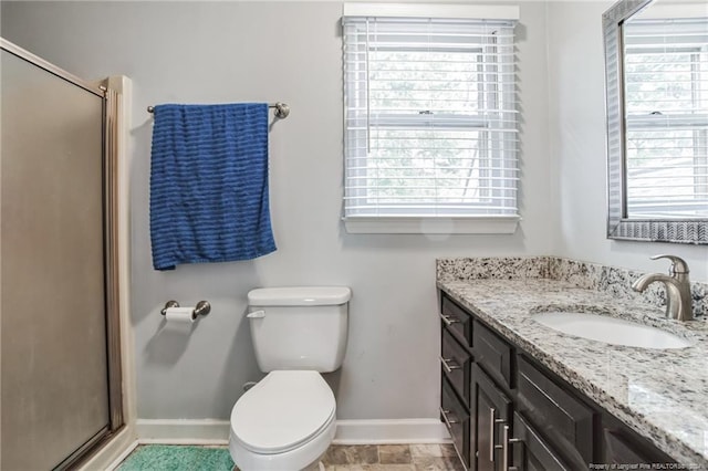 bathroom with a shower with shower door, vanity, tile patterned flooring, and toilet