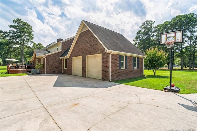 view of side of property featuring a garage, a wooden deck, and a lawn