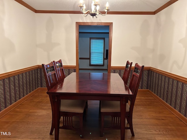 dining room featuring ornamental molding, a chandelier, and hardwood / wood-style flooring