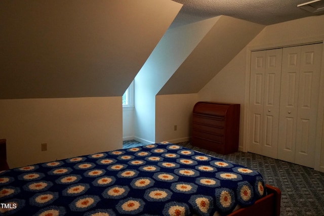 unfurnished bedroom featuring carpet floors, a textured ceiling, lofted ceiling, and a closet