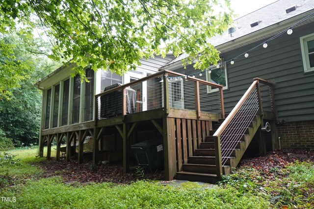 rear view of house featuring a sunroom and a deck