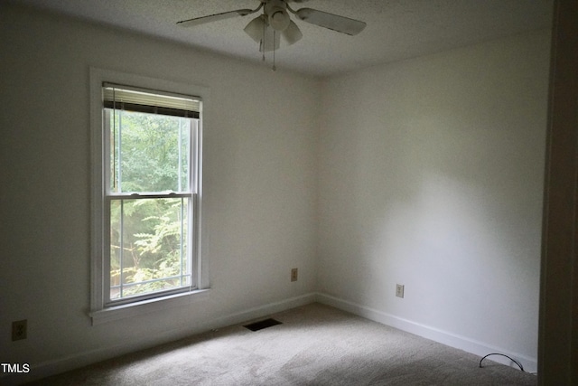 empty room with ceiling fan and carpet