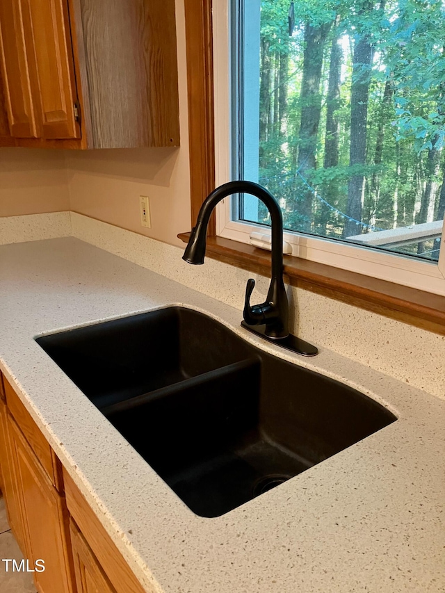 details with light stone countertops and sink