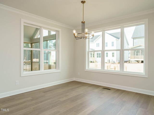 205 Wash Hollow Dr, Wendell, NC 27591 - unfurnished dining area with hardwood / wood-style flooring, crown molding, a healthy amount of sunlight, and a chandelier