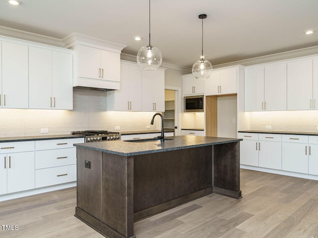 205 Wash Hollow Dr, Wendell, NC 27591 - kitchen with sink, white cabinetry, ornamental molding, a center island with sink, and built in microwave