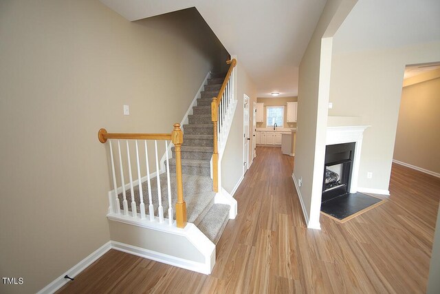 stairs featuring hardwood / wood-style floors and sink