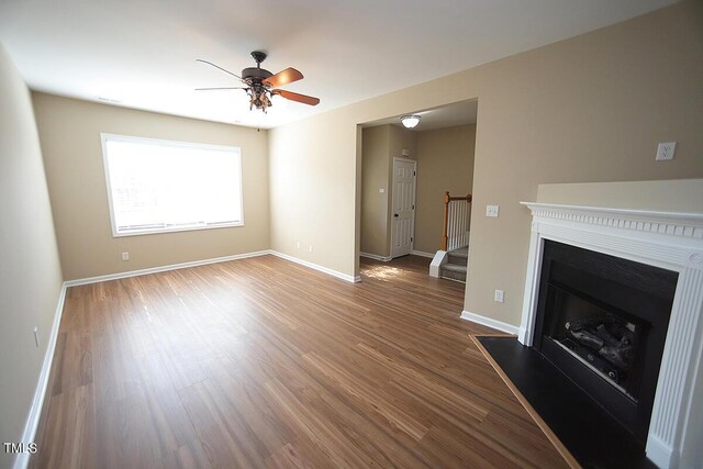 unfurnished living room featuring ceiling fan and hardwood / wood-style flooring