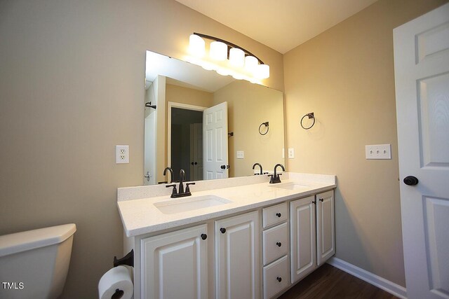 bathroom with hardwood / wood-style flooring, vanity, and toilet