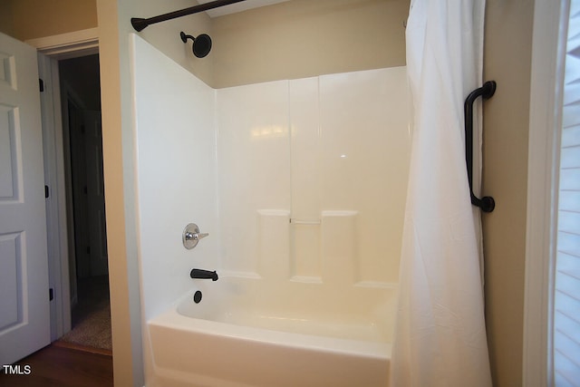 bathroom with shower / tub combo with curtain and wood-type flooring