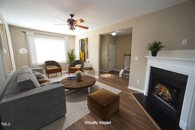 living room featuring ceiling fan and dark hardwood / wood-style floors