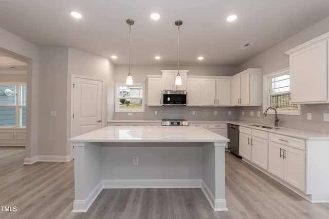 kitchen with white cabinets, sink, a center island, and appliances with stainless steel finishes