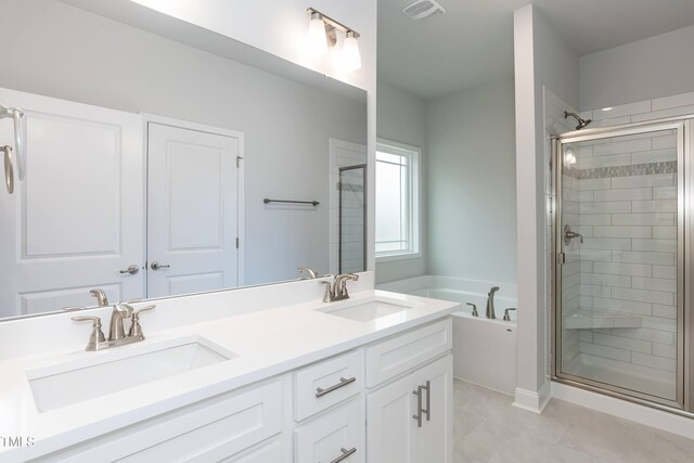 bathroom featuring tile patterned flooring, vanity, and shower with separate bathtub