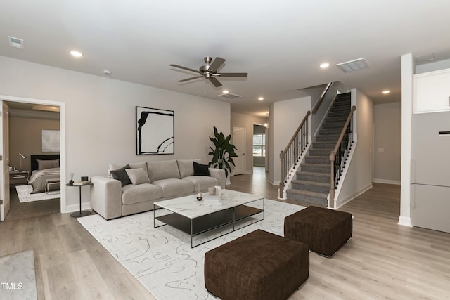 living room featuring ceiling fan and light hardwood / wood-style floors