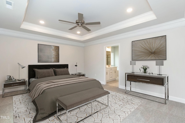 bedroom featuring ceiling fan, a raised ceiling, light colored carpet, and ensuite bathroom