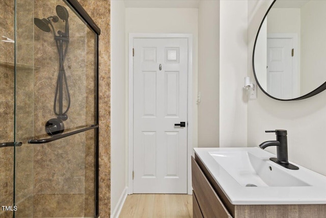 bathroom with vanity, walk in shower, and hardwood / wood-style floors