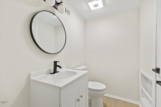 bathroom with vanity, hardwood / wood-style flooring, and toilet