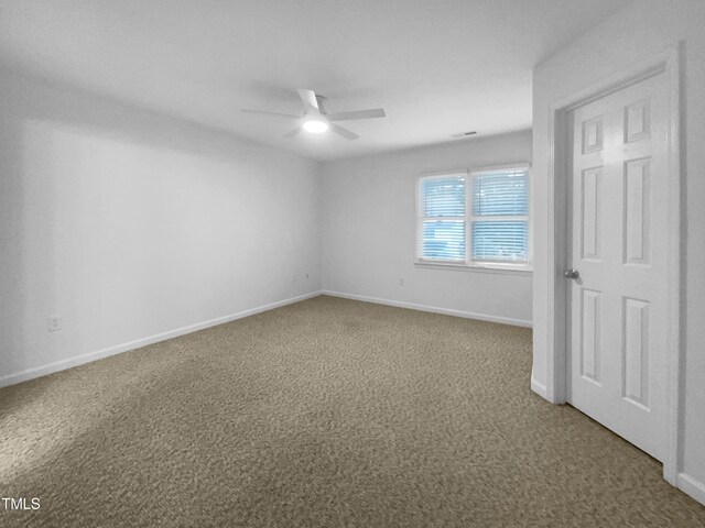 spare room with ceiling fan and carpet