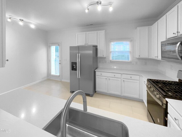 kitchen with sink, white cabinetry, ornamental molding, and appliances with stainless steel finishes