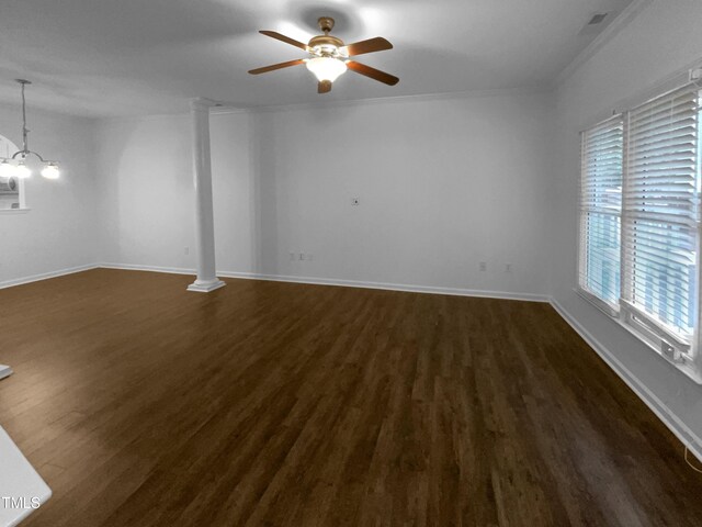 unfurnished room featuring crown molding, a healthy amount of sunlight, ornate columns, and dark hardwood / wood-style flooring