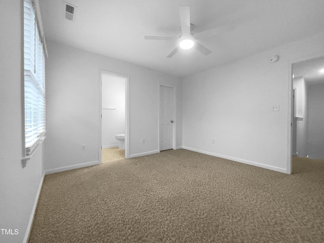 unfurnished bedroom with ceiling fan, ensuite bathroom, and carpet flooring