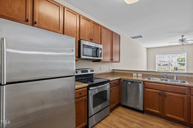 kitchen with sink, light hardwood / wood-style flooring, ceiling fan, and stainless steel appliances