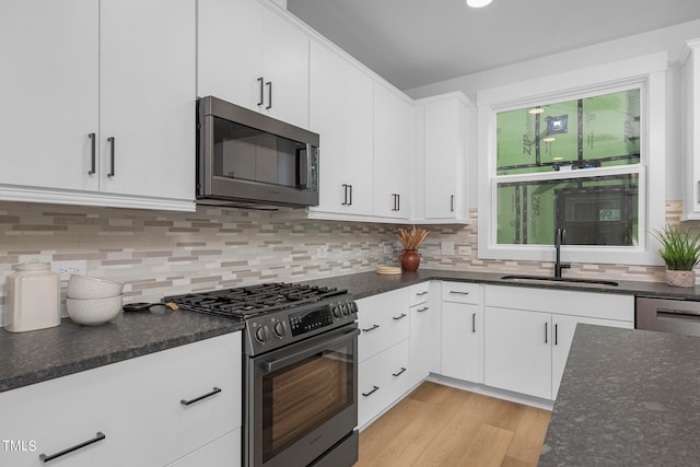 kitchen featuring stainless steel appliances, white cabinetry, and sink