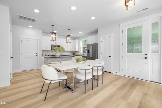 dining space with sink and light hardwood / wood-style floors