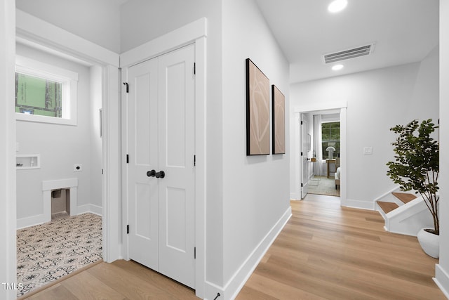 hallway featuring a wealth of natural light and light hardwood / wood-style floors