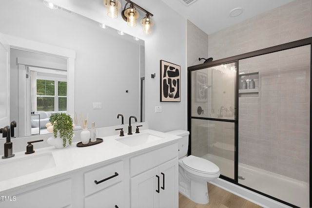 bathroom featuring walk in shower, vanity, toilet, and hardwood / wood-style flooring