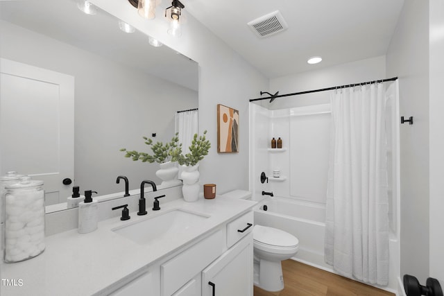 full bathroom with shower / tub combo with curtain, vanity, hardwood / wood-style flooring, and toilet