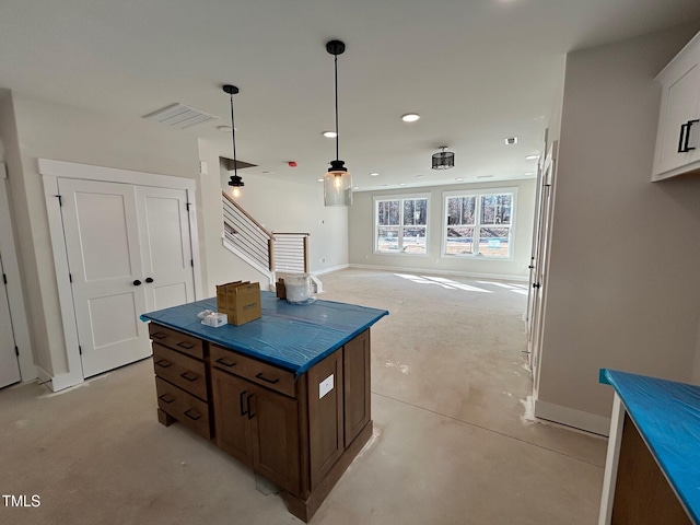 kitchen with white cabinetry, hanging light fixtures, and a kitchen island